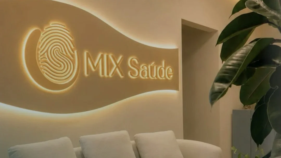 Recepção da MIX Saúde com o sofá e a marca iluminada na parede